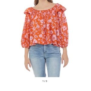 100% cotton . Elasticized neckline. Ruffle shoulder detail. Puff sleeve.